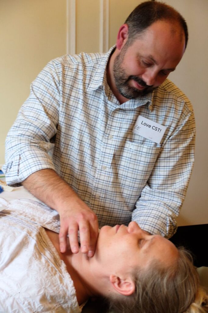 Man applying CranioSacral Therapy techniques from CST course from scratch.