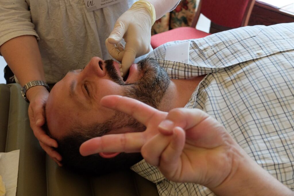Man receiving CranioSacral Therapy as part of CST course from scratch.