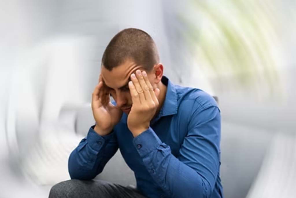 A man holding his head with a swirl around him